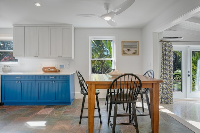 dining area with a wall unit AC and ceiling fan