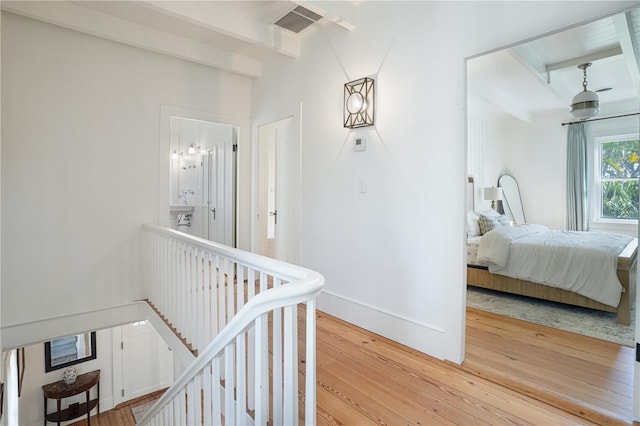 hallway with beamed ceiling and hardwood / wood-style floors