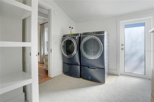 laundry room featuring washing machine and clothes dryer and light carpet