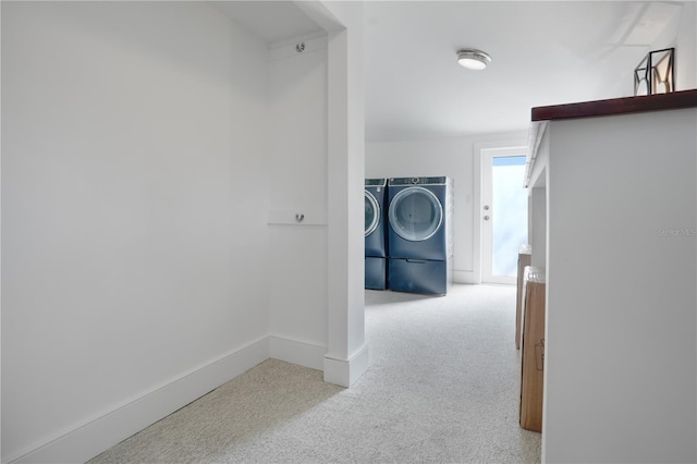 hallway featuring light colored carpet and washing machine and clothes dryer