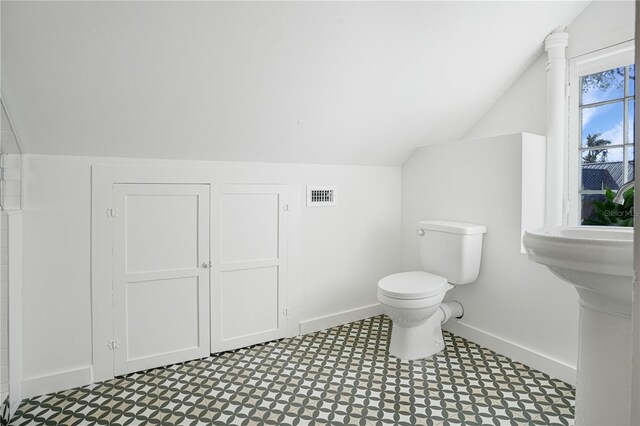 bathroom with lofted ceiling and toilet