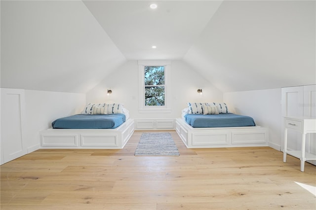 unfurnished bedroom featuring vaulted ceiling and light hardwood / wood-style floors