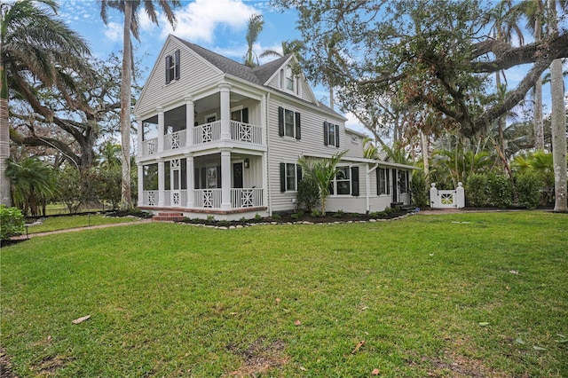 rear view of property featuring a balcony and a lawn