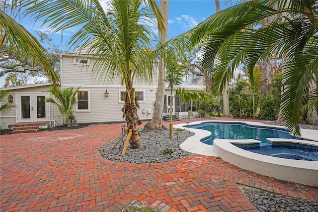 view of pool featuring french doors, an in ground hot tub, and a patio