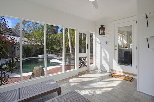 unfurnished sunroom with ceiling fan