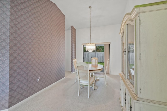 carpeted dining space featuring a chandelier