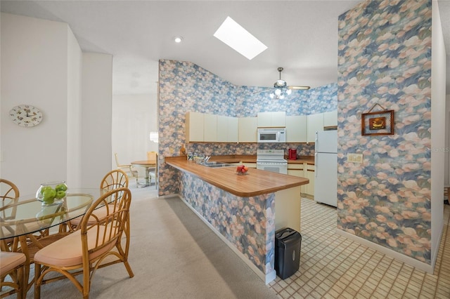 kitchen with ceiling fan, sink, backsplash, kitchen peninsula, and white appliances