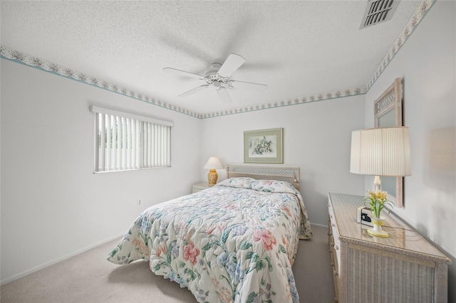 bedroom featuring a textured ceiling, light colored carpet, and ceiling fan