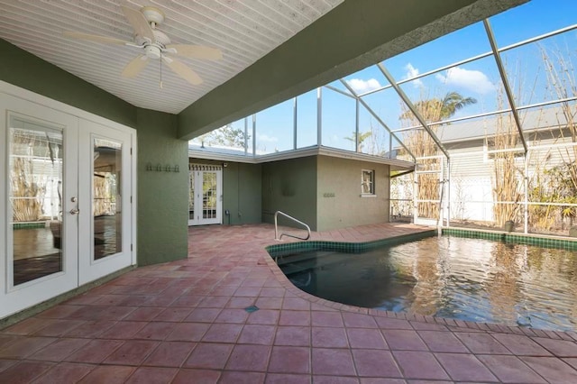 view of swimming pool with french doors, ceiling fan, glass enclosure, and a patio