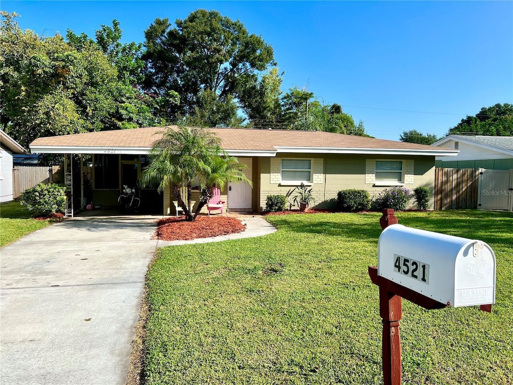 ranch-style house with a carport and a front lawn