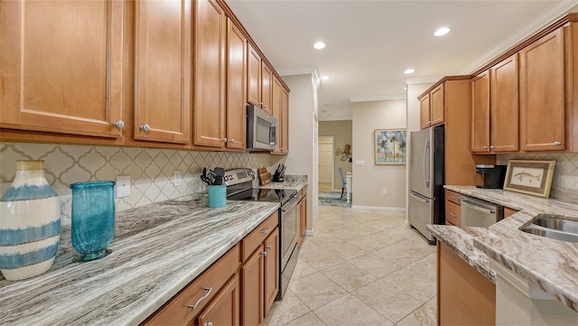 kitchen with light stone countertops, light tile patterned floors, backsplash, appliances with stainless steel finishes, and ornamental molding