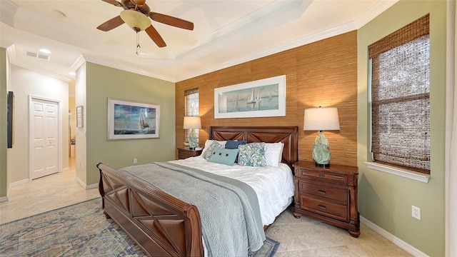 bedroom featuring ceiling fan, light tile patterned floors, ornamental molding, and a tray ceiling