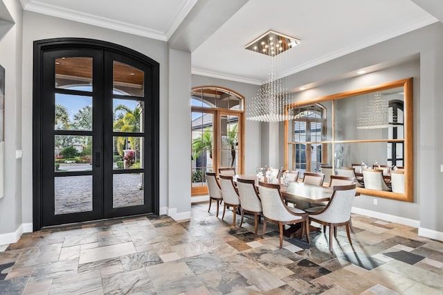 dining space with crown molding, an inviting chandelier, and french doors