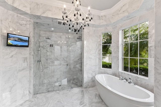 bathroom with tile walls, shower with separate bathtub, an inviting chandelier, and a healthy amount of sunlight