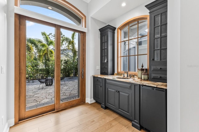 doorway featuring sink and light hardwood / wood-style flooring