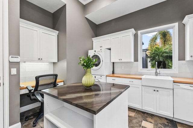 kitchen with dishwasher, white cabinetry, sink, stacked washer / dryer, and butcher block countertops