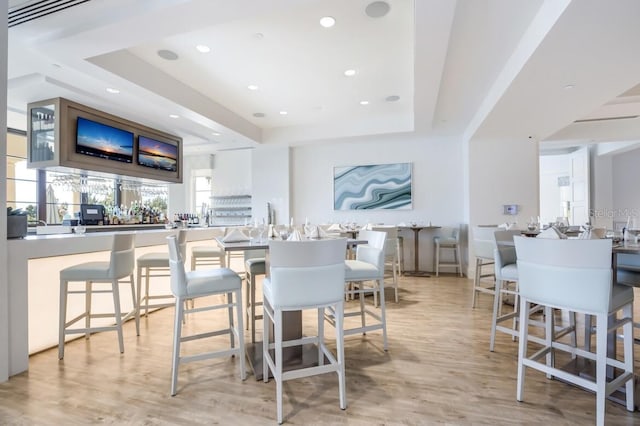 dining room with light hardwood / wood-style floors and a tray ceiling