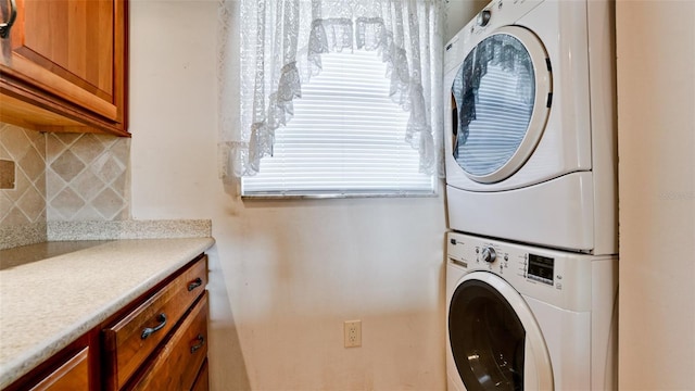 laundry room with cabinets and stacked washer and dryer