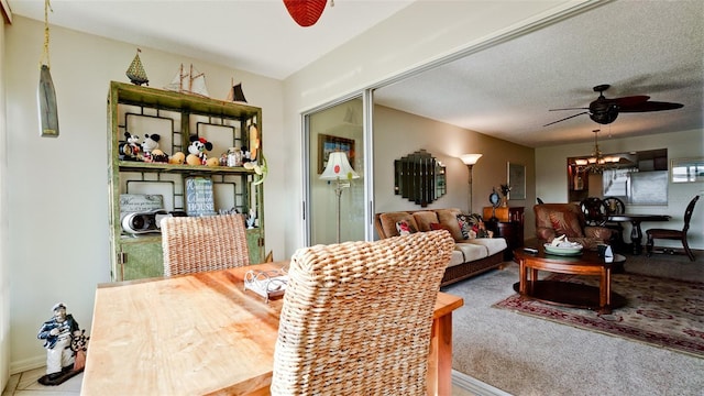 carpeted dining area with ceiling fan and a textured ceiling