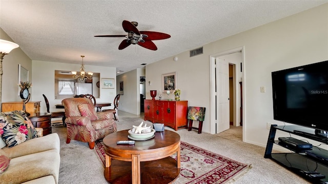 carpeted living room featuring ceiling fan with notable chandelier and a textured ceiling