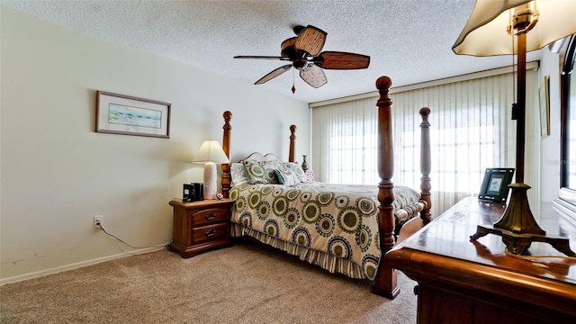 bedroom featuring ceiling fan, light colored carpet, and a textured ceiling