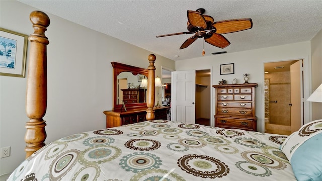 bedroom featuring a textured ceiling, a closet, ensuite bath, and ceiling fan