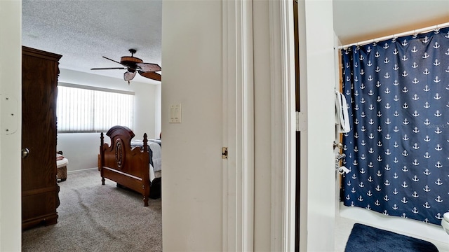 bedroom with ceiling fan, light colored carpet, and a textured ceiling