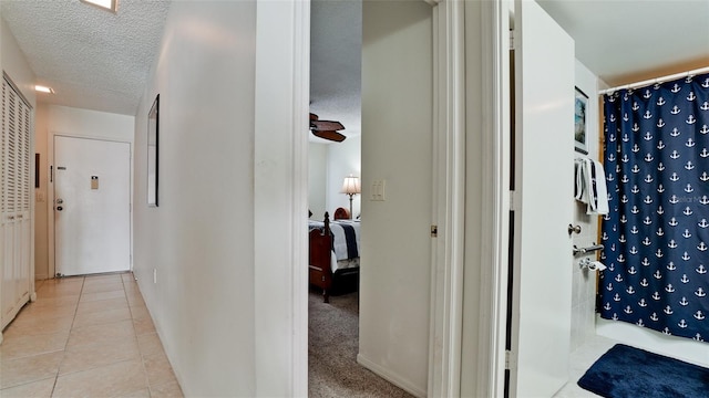 hallway with light tile patterned flooring and a textured ceiling