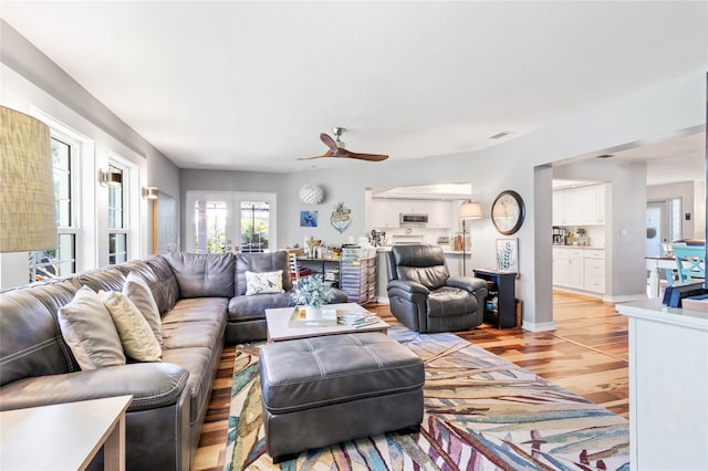 living room with french doors, light hardwood / wood-style flooring, and ceiling fan