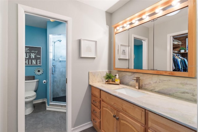 bathroom with tile patterned flooring, vanity, toilet, and a shower with shower door