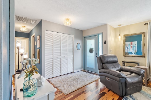 entryway featuring wood-type flooring and a textured ceiling