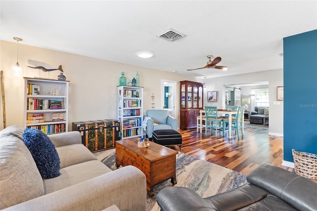 living room featuring hardwood / wood-style floors and ceiling fan