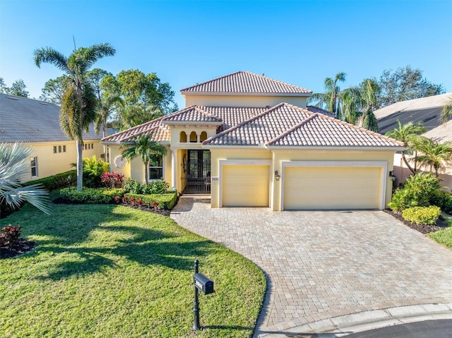 mediterranean / spanish home with a garage and a front lawn