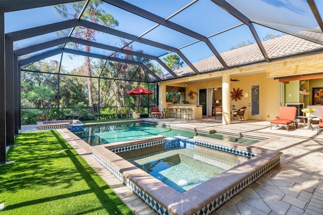 view of swimming pool with glass enclosure, ceiling fan, a patio area, an in ground hot tub, and a bar