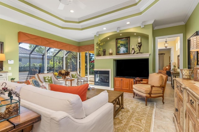 living room featuring a raised ceiling, crown molding, and ceiling fan