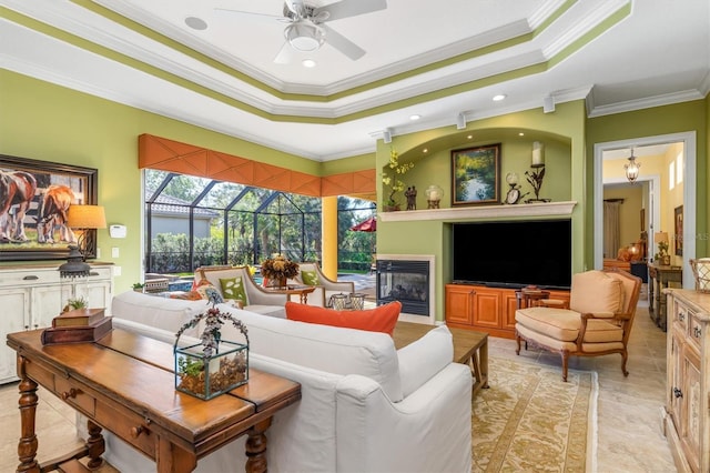 living room featuring a tray ceiling, ceiling fan, and ornamental molding