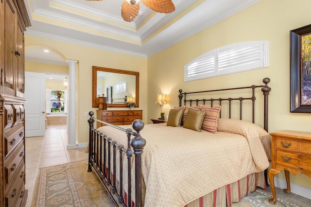 tiled bedroom featuring ceiling fan, ornamental molding, a tray ceiling, and ornate columns