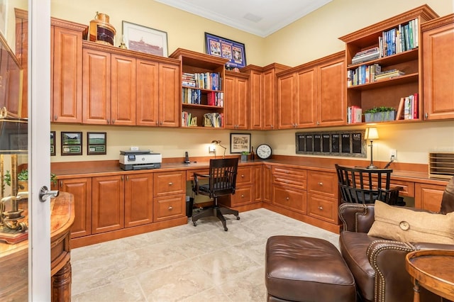 home office with built in desk and ornamental molding