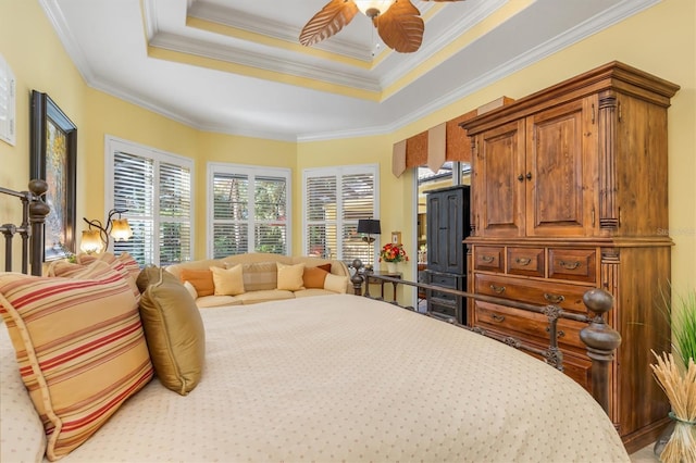 bedroom featuring a tray ceiling, ceiling fan, and ornamental molding