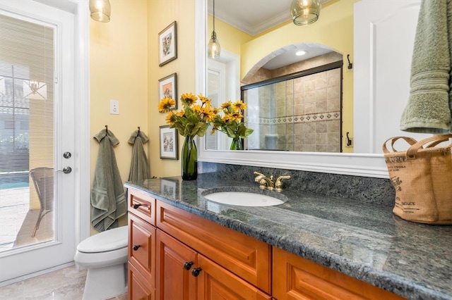 bathroom with tile patterned flooring, crown molding, toilet, vanity, and a shower with shower door