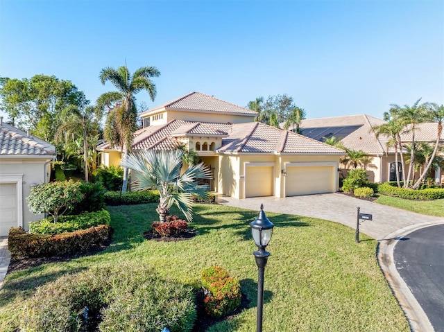 mediterranean / spanish-style home featuring a garage and a front lawn