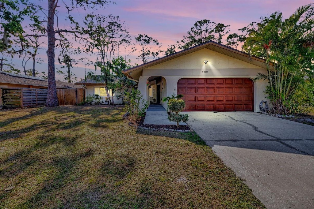 ranch-style home with a lawn and a garage