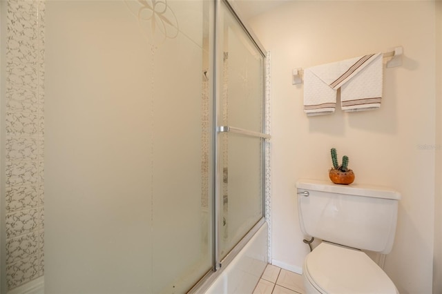 bathroom featuring tile patterned floors, toilet, and enclosed tub / shower combo