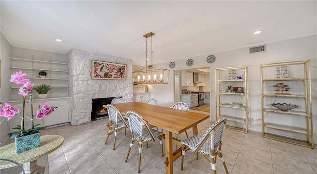 tiled dining room featuring crown molding and a fireplace