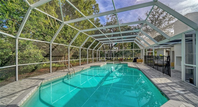 view of pool with a patio area and glass enclosure