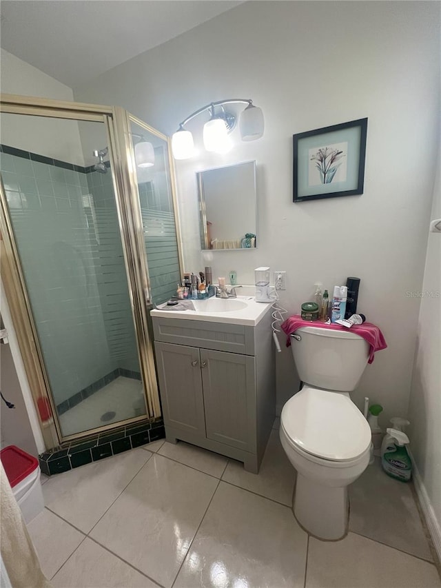 bathroom with tile patterned floors, a shower with door, vanity, and toilet