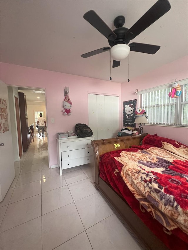 bedroom with ceiling fan, a closet, and light tile patterned floors