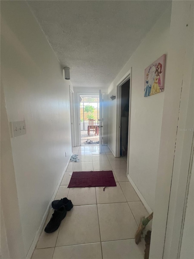 hallway with light tile patterned flooring and a textured ceiling