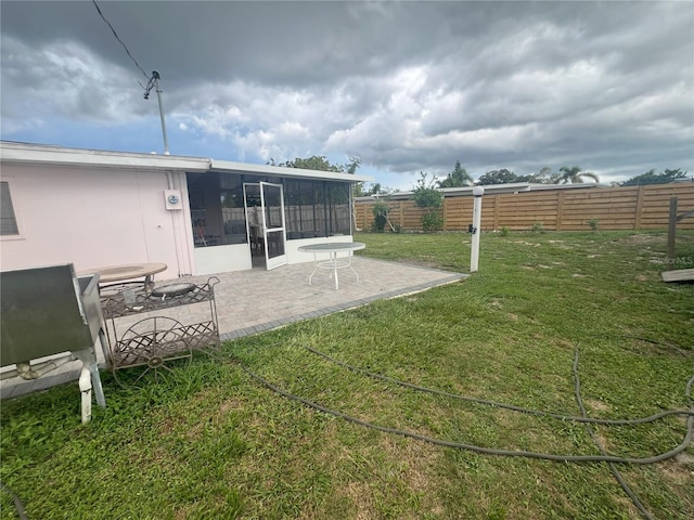 view of yard featuring a sunroom and a patio