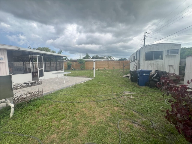 view of yard with a sunroom and a patio area